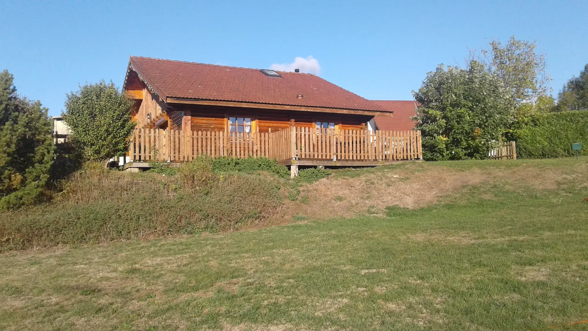 Le Chalet Peter au milieu des haies et des arbres du domaine