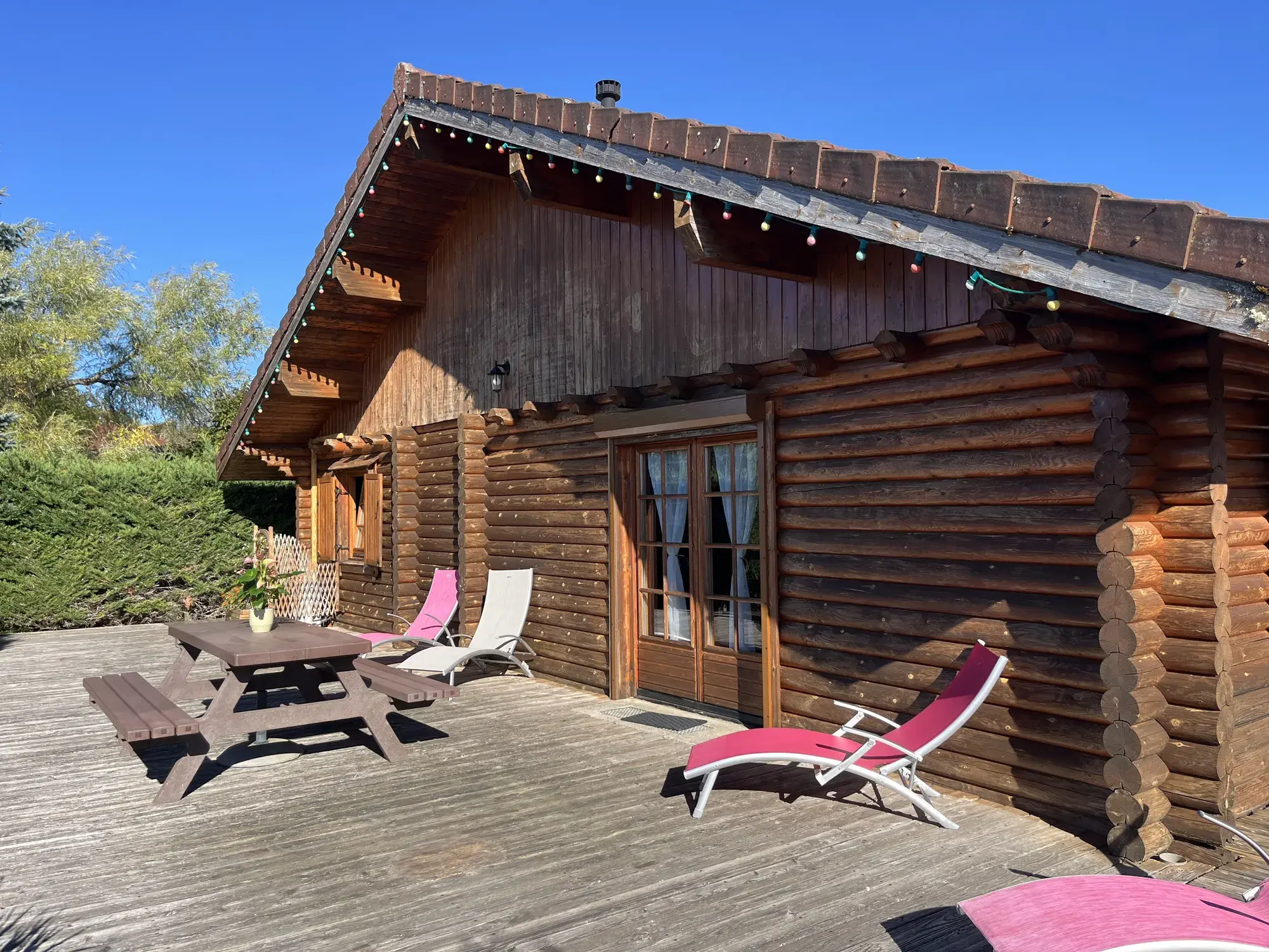 Terrasse du Chalet Manon, table de pique-nique et transats au soleil